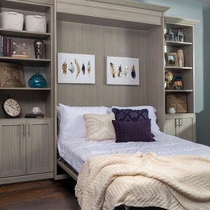 Flip out bed in bedroom with storage cabinets